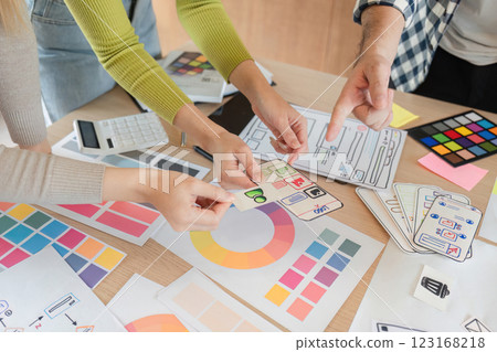 Diverse team reviewing design mockups during brainstorming session at office. 123168218