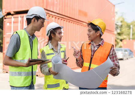 Construction professionals discussing blueprints and site plans while collaborating at a project location 123168278