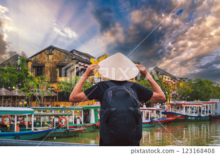 back of male tourist traveler in Vietnamese hat on a bridge in old town in Hoi An in Vietnam in Asia 123168408