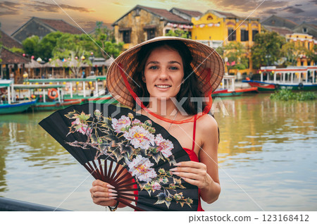 happy young woman tourist traveler in Vietnamese hat on a bridge in Hoi An in Vietnam in Asia 123168412