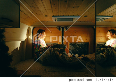 Young caucasian female child girl relaxing in cozy wooden camper interior with soft lighting and Young caucasian female child girl relaxing in cozy wooden camper interior with soft lighting and 123168517