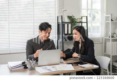 Business professionals collaborating on financial analysis in a modern office setting. Business professionals collaborating on financial analysis in a modern office setting. 123168600
