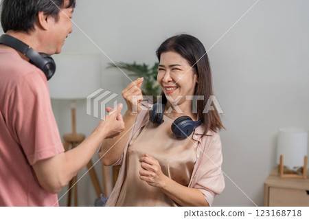 Diverse couple having fun and dancing together in a cozy living room. 123168718