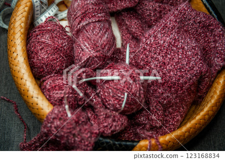 yarns, knitting needles and pattern sample in basket on sofa. yarns, knitting needles and pattern sample in basket on sofa. 123168834