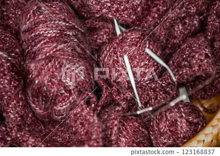 yarns, knitting needles and pattern sample in basket on sofa. yarns, knitting needles and pattern sample in basket on sofa. 123168837