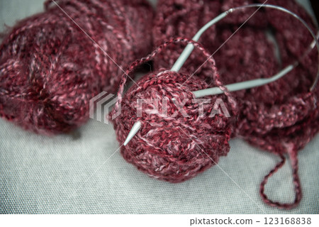 yarns, knitting needles and pattern sample on grey background. 123168838