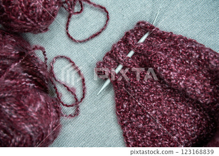 yarns, knitting needles and pattern sample on grey background. 123168839
