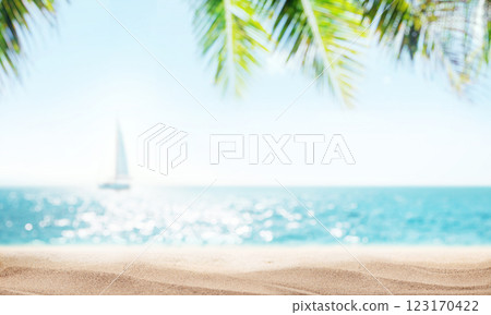 A serene seaside view with soft-focus palm leaves in the foreground and a sailboat gently gliding on the horizon 123170422
