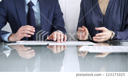 Business partners or lawyers are discussing contract papers during a meeting, negotiating and making decisions together. Business people concept, close up Business partners or lawyers are discussing contract papers during a meeting, negotiating and making decisions together. Business people concept, close up 123171025