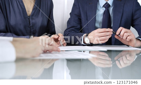 Business partners or lawyers are reviewing contract terms during a meeting, negotiating and making decisions together. Business people concept, close up view 123171046