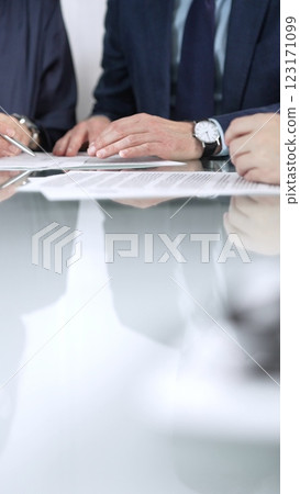 Business people are discussing a contract during meeting while sitting at the glass table in office, vertical close up view. Concept of success and team work 123171099
