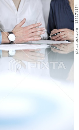 Business people are reviewing contract terms during a meeting, negotiating and making decisions together, vertical close up view. Copy space area Business people are reviewing contract terms during a meeting, negotiating and making decisions together, vertical close up view. Copy space area 123171174