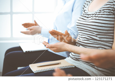 Business people clapping at meeting or conference, close-up of hands. Group of unknown businessmen and women in modern white office. Success teamwork, corporate coaching and applause concept Business people clapping at meeting or conference, close-up of hands. Group of unknown businessmen and women in modern white office. Success teamwork, corporate coaching and applause concept 123171271