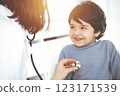 Doctor-woman examining a child patient by stethoscope in sunny clinik. Medicine concept 123171539
