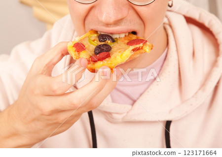 Bearded Caucasian white mature male in pink t-shirt eating delicious pizza slices 123171664
