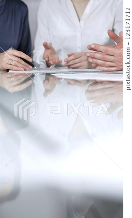 Business people are reviewing contract terms during a meeting, negotiating and making decisions together, vertical close up view. Copy space area 123171712