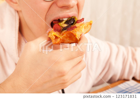 Bearded Caucasian white mature male in pink t-shirt eating delicious pizza slices Bearded Caucasian white mature male in pink t-shirt eating delicious pizza slices 123171831