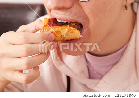 Bearded Caucasian white mature male in pink t-shirt eating delicious pizza slices Bearded Caucasian white mature male in pink t-shirt eating delicious pizza slices 123171840