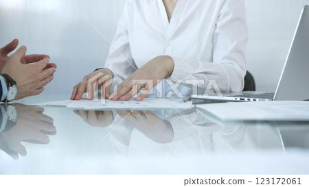 Business partners or lawyers are analyzing documents and collaborating on a project during a productive office meeting while sitting at the glass table. Businesspeople concept 123172061