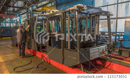 Conveyor assembly stage the body of tractor at big industrial factory timelapse Conveyor assembly stage the body of tractor at big industrial factory timelapse 123173031