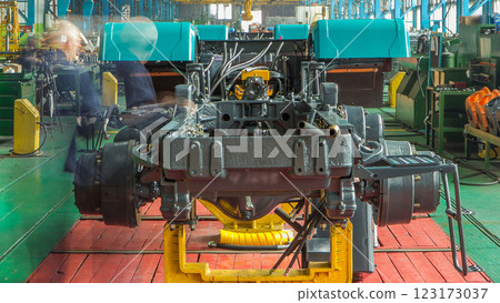 Conveyor assembly stage the body of tractor at big industrial factory timelapse Conveyor assembly stage the body of tractor at big industrial factory timelapse 123173037