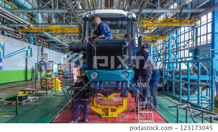 Conveyor assembly stage the body of tractor at big industrial factory timelapse Conveyor assembly stage the body of tractor at big industrial factory timelapse 123173045