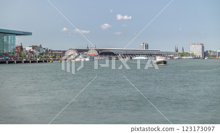 Panoramic view of Amsterdam Central Station with its curved roof and the Amstel River timelapse. Amsterdam, Netherlands 123173097