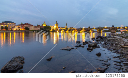 The Charles Bridge day to night timelapse over the Vltava River reflected in water in Prague, Czech Republic 123173260