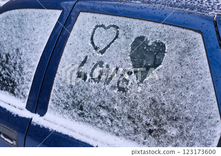 love was written on the glass of the car in the snow and two hearts were painted love was written on the glass of the car in the snow and two hearts were painted 123173600