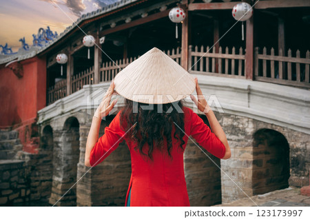 back of girl traveler tourist in Vietnamese hat at ancient Japanese covered bridge in old town in Hoi An in Vietnam 123173997