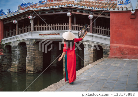 back of woman traveler tourist in a Vietnamese hat at ancient Japanese covered bridge in old town in Hoi An in Vietnam in Asia 123173998