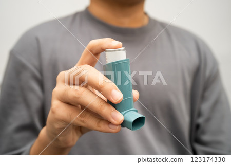 Asthma and chronic obstructive pulmonary disease COPD, Asian young man using metered dose inhaler MDI. 123174330