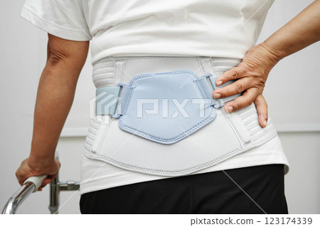 Asian woman wearing lumbar support pain back and use walker in hospital. Asian woman wearing lumbar support pain back and use walker in hospital. 123174339