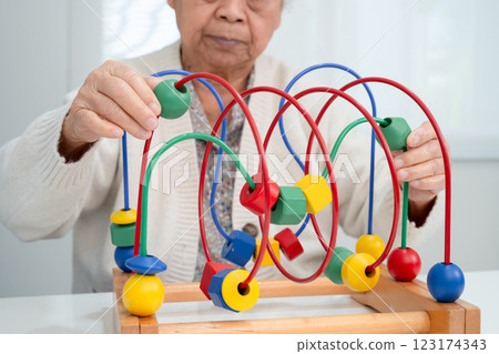 Asian elderly woman playing enhancing skill board game. 123174343