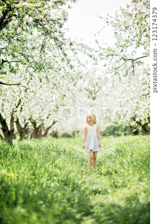 girl sniffing flowers of apple orchard. garden with flowering trees. Allergy season. Soft focus. Girl enjoying floral aroma. Child enjoy life without allergy. girl sniffing flowers of apple orchard. garden with flowering trees. Allergy season. Soft focus. Girl enjoying floral aroma. Child enjoy life without allergy. 123174379