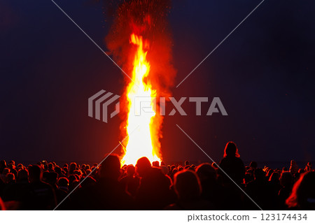 Scenic view of people crowd gathering celebrate traditional big Easter bonfire at twilight night in Germany. Walpurgis night fire party outdoors 123174434