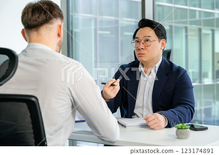 Professional Business Discussion Between Two Men in Modern Office Setting Professional Business Discussion Between Two Men in Modern Office Setting 123174891