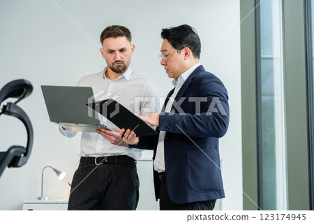 Two Business Professionals Collaborating and Analyzing Data in a Modern Office Two Business Professionals Collaborating and Analyzing Data in a Modern Office 123174945