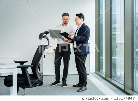Two Professionals Collaborating on a Project in a Modern Office Environment Two Professionals Collaborating on a Project in a Modern Office Environment 123174947