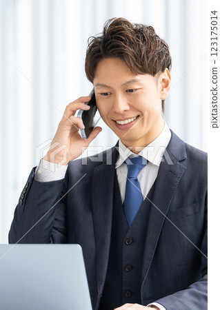Smiling male businessman talking on a smartphone Smiling male businessman talking on a smartphone 123175014