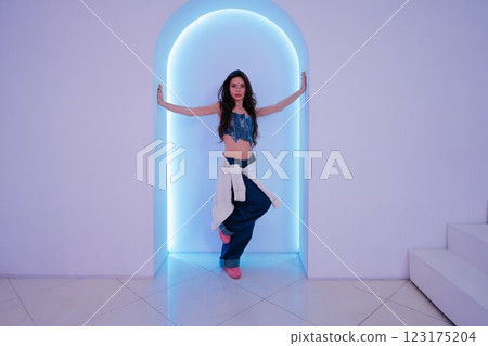 Stylish young woman posing elegantly in a modern studio setting Stylish young woman posing elegantly in a modern studio setting 123175204