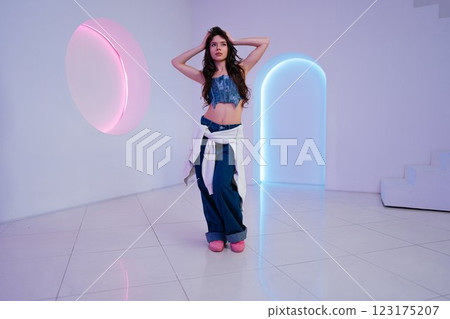 Young woman posing in modern indoor space with colorful lighting effects Young woman posing in modern indoor space with colorful lighting effects 123175207