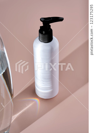 White bottles of bath product on a powdery pink background. 123175295