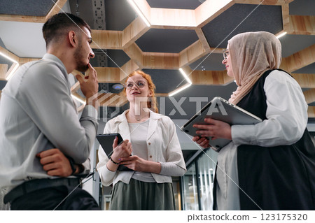 Young group of business people brainstorming together in a startup space, discussing business projects, investments, and solving challenges. 123175320