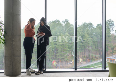 Two colleagues are having a productive conversation while looking at a tablet. 123175326