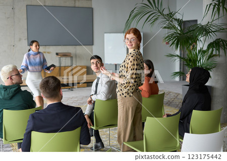 A diverse group of business professionals sits attentively in a modern office, actively participating in a training session led by an instructor, focusing on the latest technological advancements in A diverse group of business professionals sits attentively in a modern office, actively participating in a training session led by an instructor, focusing on the latest technological advancements in 123175442