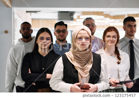 A group of business professionals standing together, taking a well-deserved break from their busy workday, showcasing camaraderie, teamwork, and a moment of relaxation in their dynamic workplace 123175457