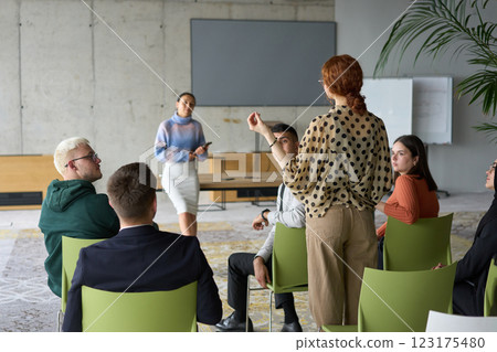 A diverse group of business professionals sits attentively in a modern office, actively participating in a training session led by an instructor, focusing on the latest technological advancements in A diverse group of business professionals sits attentively in a modern office, actively participating in a training session led by an instructor, focusing on the latest technological advancements in 123175480