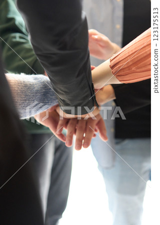 A top view of business people joining hands in a circle, symbolizing unity, collaboration, and shared success in the workplace 123175513