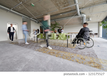 Business Team Led by Director in a Wheelchair Preparing for a Meeting in a Modern Office. 123175527